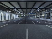 a street with empty lanes and lights is shown at night with no people around it