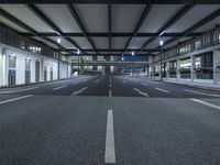 a street with empty lanes and lights is shown at night with no people around it