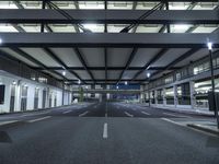 a street with empty lanes and lights is shown at night with no people around it