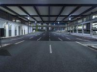 a street with empty lanes and lights is shown at night with no people around it