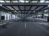 a street with empty lanes and lights is shown at night with no people around it