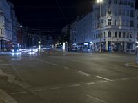 a city intersection that is empty at night time with cars waiting to cross the intersection