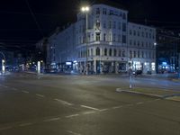 a city intersection that is empty at night time with cars waiting to cross the intersection