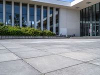 there are buildings and plants outside a building that is empty, with glass windows looking on