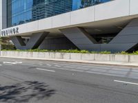 the entrance to a tall office building is empty and ready to be built into the side of a road