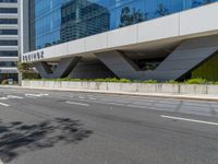 the entrance to a tall office building is empty and ready to be built into the side of a road