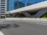 the entrance to a tall office building is empty and ready to be built into the side of a road