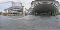 a panoramic picture of an empty building with palm trees and buildings in the background