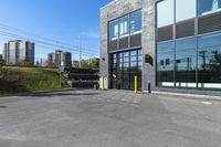 an empty commercial building with a car park in front of it on a sunny day