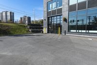 an empty commercial building with a car park in front of it on a sunny day