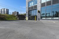 an empty commercial building with a car park in front of it on a sunny day