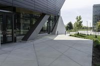 an empty concrete ground and a glassy building on a cloudy day with no people around