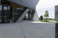 an empty concrete ground and a glassy building on a cloudy day with no people around