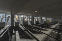 an empty office room with windows letting in sunlight and shadows all around it and on the floor