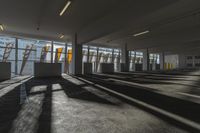 an empty office room with windows letting in sunlight and shadows all around it and on the floor