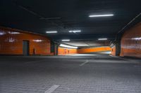 an empty orange tunnel in an industrial building with its bright lights on the walls, lighting from above