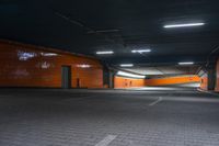 an empty orange tunnel in an industrial building with its bright lights on the walls, lighting from above