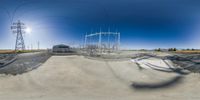 a 360 - angle view of an empty park with power lines above it and electric towers in the background