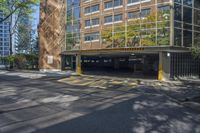 an empty parking area in front of a multistory building surrounded by apartment buildings