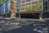 an empty parking area in front of a multistory building surrounded by apartment buildings