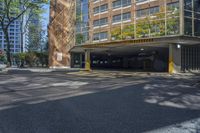 an empty parking area in front of a multistory building surrounded by apartment buildings