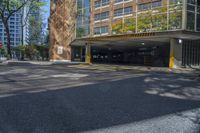 an empty parking area in front of a multistory building surrounded by apartment buildings