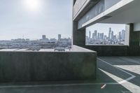 the empty parking area has concrete in it and the sky can be seen from a balcony