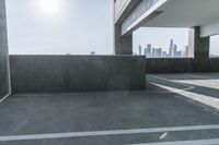 the empty parking area has concrete in it and the sky can be seen from a balcony