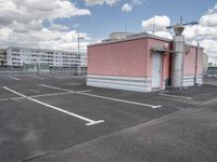 an empty parking lot with some buildings and white lines in the pavement outside of it