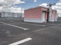 an empty parking lot with some buildings and white lines in the pavement outside of it