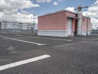 an empty parking lot with some buildings and white lines in the pavement outside of it