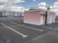 an empty parking lot with some buildings and white lines in the pavement outside of it