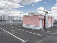 an empty parking lot with some buildings and white lines in the pavement outside of it