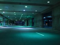 empty parking garage area with two rows of lights glowing on the ground, along with traffic in between