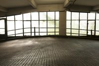 empty parking garage with lots of windows overlooking trees and a window with glass panes