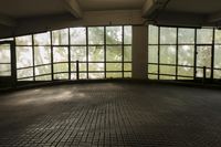 empty parking garage with lots of windows overlooking trees and a window with glass panes
