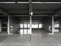 a large empty parking garage with several seats and an area for bicycles to sit on