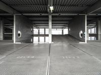 a large empty parking garage with several seats and an area for bicycles to sit on