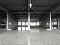 a large empty parking garage with several seats and an area for bicycles to sit on