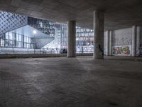 there is a skateboard in an empty parking garage area in front of several tall buildings