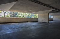 an empty parking garage with trees in the background and floor to ceiling tiles on the ground