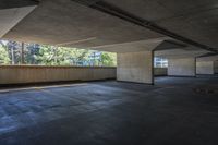 an empty parking garage with trees in the background and floor to ceiling tiles on the ground