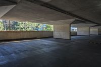 an empty parking garage with trees in the background and floor to ceiling tiles on the ground