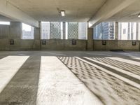 an empty parking garage is filled with parking meters and fire hydrants, some casting shadows