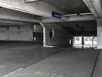 an empty parking garage filled with parking meters and one blue arrow pointing to the left