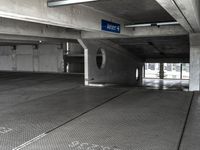 an empty parking garage filled with parking meters and one blue arrow pointing to the left