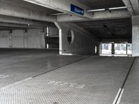 an empty parking garage filled with parking meters and one blue arrow pointing to the left