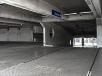 an empty parking garage filled with parking meters and one blue arrow pointing to the left