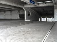 an empty parking garage filled with parking meters and one blue arrow pointing to the left