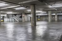 an empty parking garage with stairs and concrete walls is pictured in this image taken in daylight